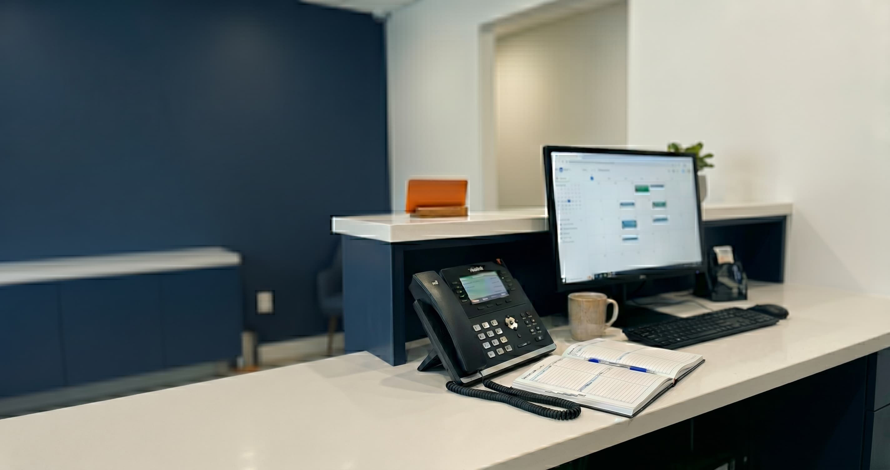 Dental front desk team reviewing an AI assistant dashboard on a computer while phones ring and patients wait in a clinic